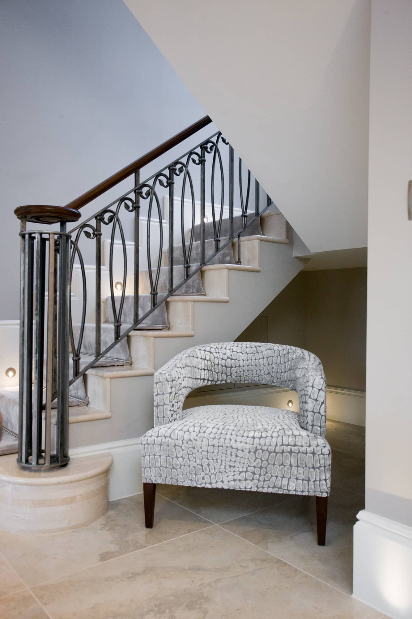 a white chair sitting beside a stair case.